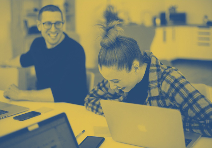 A stylized image of a guy and a girl laughing at a desk.