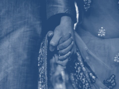 A stylized image of a couple holding hands in traditional Indian garb.